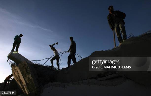 Palestinian men use sledgehammers to smash concrete and collect scrap iron from the wreckage of factories that were demolished by the Israeli army...