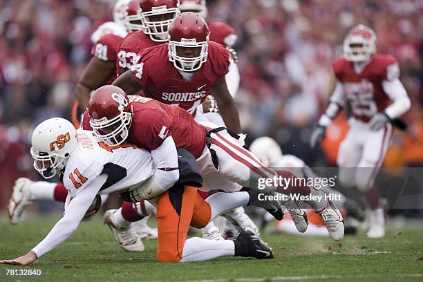 Zac Robinson of the Oklahoma State Cowboys is tackled by Nic Harris of the Oklahoma Sooners at Gaylord Family-Oklahoma Memorial Stadium on November...