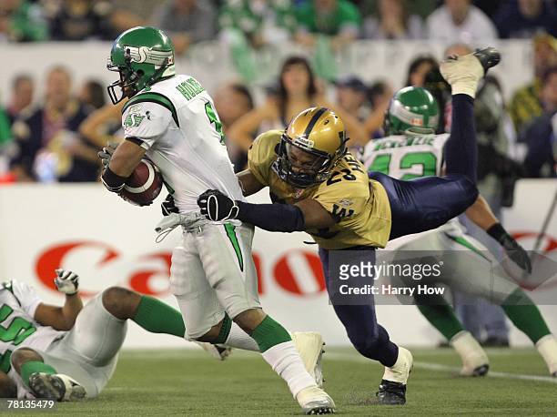 Neil Wilson of the Saskatchewan Rough Riders breaks away from the tackle of Kyries Hebert of the Winnipeg Blue Bombers during the third quarter in...