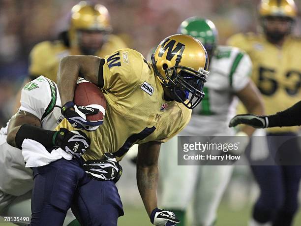 Charles Roberts of the Winnipeg Blue Bombers tries to break a tackle against the Saskatchewan Rough Riders during the first quarter of the 95th Grey...