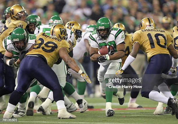 Wes Cates of the Saskatchewan Rough Riders tries to split the defense of Jerome Haywood and Ike Charlton of the Winnipeg Blue Bombers during the...