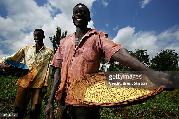 Two soy farmers stand with their product on their small plot of land in the Sauri Millenium village locale, September 11, 2007 in Kisumu, Kenya. The...