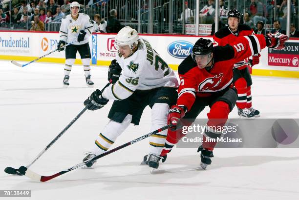 Jussi Jokinen of the Dallas Stars tries to skate past Colin White of the New Jersey Devils at the Prudential Center November 28, 2007 in Newark, New...