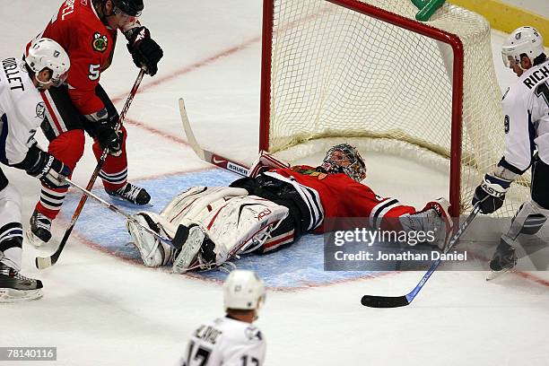 Goalie Nikolai Khabibulin of the Chicago Blackhawks covers the puck with his legs to make a save against the Tampa Bay Lightning at the United Center...