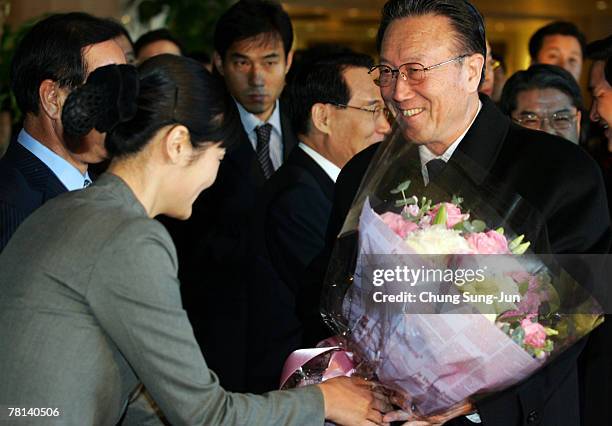 North Korea's United Front Department of Workers' Party Director Kim Yang-Gon is handed flowers upon his arrival at a Walkerhill Hotel on November...