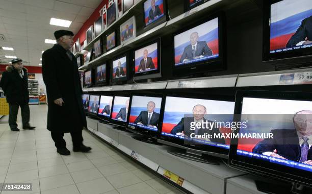 Customer looks at TV sets on display in Moscow shop showing Russian President Vladimir Putin's address to the nation, 29 November 2007. Putin warned...