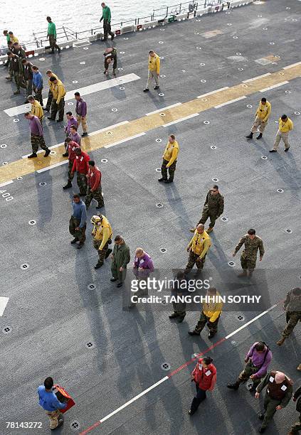 Sailors walk in line as they clean up the deck of the USS Essex, upon arrival at Sihanouk Ville town, some 220 kilometers southwest of Phnom Penh, 26...