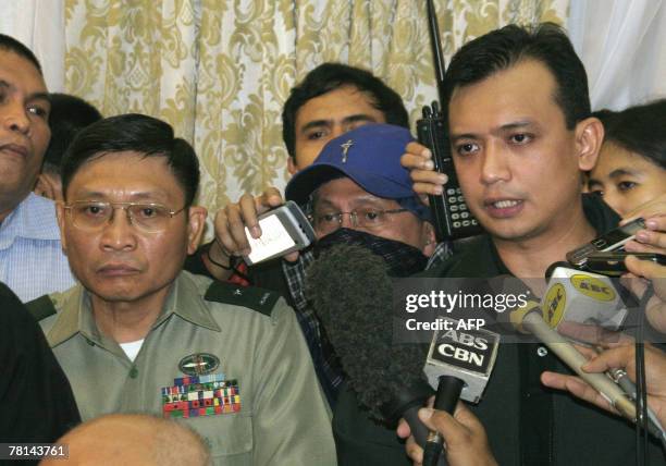 Philippine rebel officer, army Brigadier General Danilo Lim , looks on while Antonio Trillanes , a navy lieutenant who was elected senator in May,...