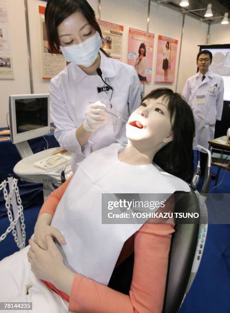 Japan's Nippon Dental University Hospital staff Yuko Uchida demonstrates a humanoid robot of dental therapy simulator "Simroid" for dentists and...