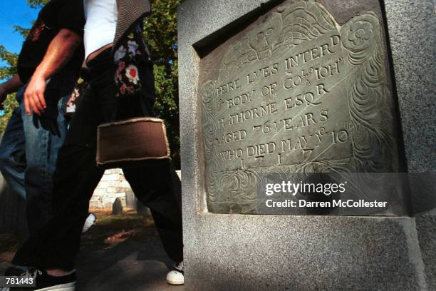 Tourists walk by the gravestone of Judge John Hathorne October 26, 2000 in the nations second oldest graveyard in Salem, MA. Hathorne presided over...