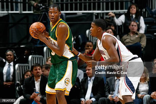 Kevin Durant of the Seattle SuperSonics is defended by Joe Johnson of the Atlanta Hawks during the game on November 16, 2007 at Philips Arena in...
