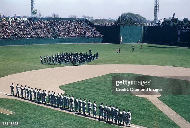 Members of the New York Yankees line up on the thirdbase line as the marching band heads towards the centerfield flagpole for the National Anthem and...