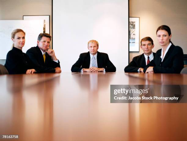 businesspeople sitting at a boardroom table - boardmember stock pictures, royalty-free photos & images