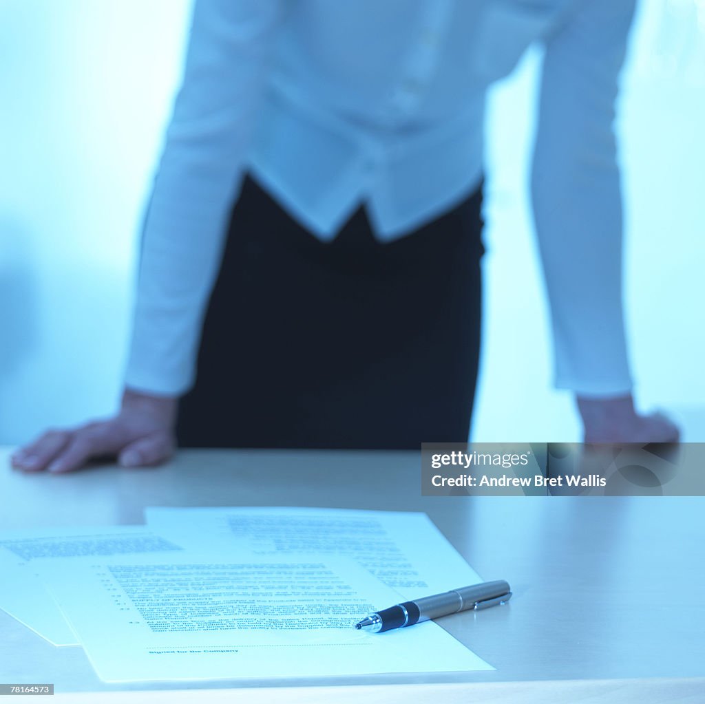 Businesswoman leaning over desk