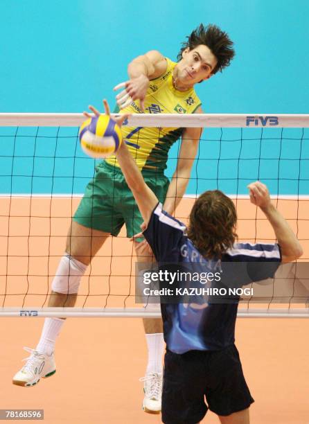 Brazilian volleyball star Gilberto Godoy Filho "Giba" spikes the ball over Argentina's Guillermo Garcia during their match at the FIVB Men's World...