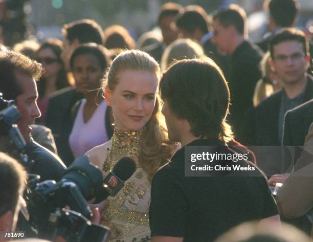 Actress Nicole Kidman and her husband Actor Tom Cruise, center, are swarmed by media May 18, 2000 at the world premiere of Paramount Pictures...