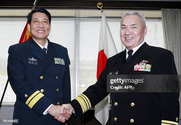 Chinese Navy South Sea Fleet vice commander Xiao Xinnian shakes hands with Koji Yoda , Commander in chief of Japanese Maritime Self Defense Force at...