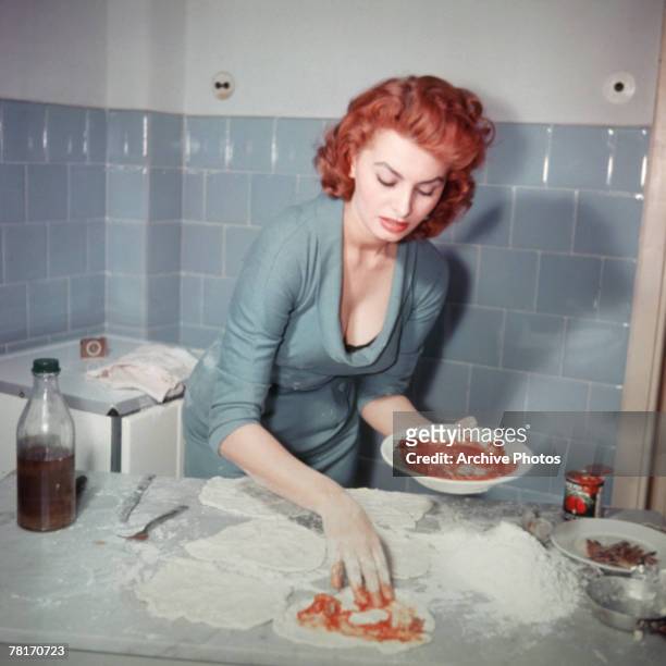 Italian actress Sophia Loren prepares an Italian dish, circa 1965.