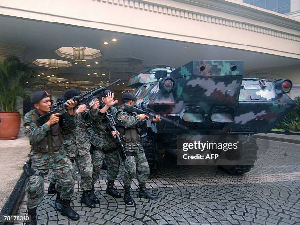 Elite police commandos begin an assault on the luxury Peninsula hotel in Manila's Makati financial district, where rebel soldiers are holed up, 29...