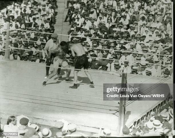 Heavyweight champ Jack Dempsey unloads a right hand as challenger Tommy Gibbons tries to cover up. Dempsey retained his title with a 15 round...