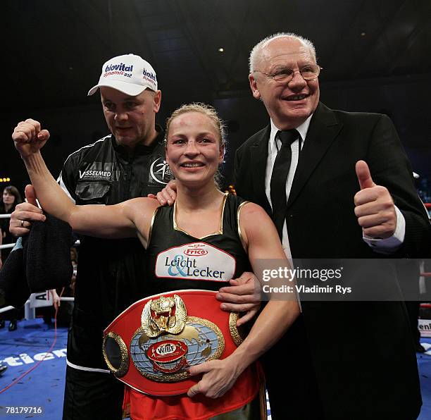 Regina Halmich of Germany poses for a photo with her coach Torsten Schmitz and boxing promoter Klaus-Peter Kohl after Hamlich defeated Hagar...