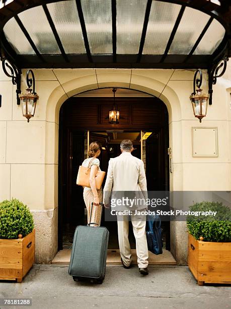 couple entering hotel entrance - hotel door stock pictures, royalty-free photos & images
