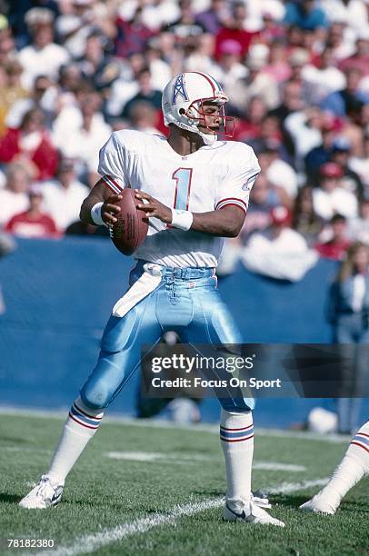 S: Quarterback Warren Moon of the Houston Oilers drops back to pass against the New England Patriots during a mid circa 1980's NFL football game at...