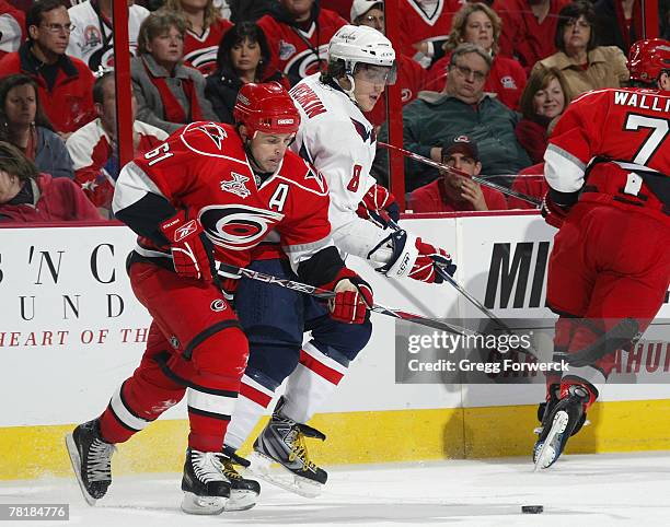 Cory Stillman of the Carolina Hurricanes and Alex Ovechkin of the Washington Capitals battle for the puck during their game on November 30, 2007 at...