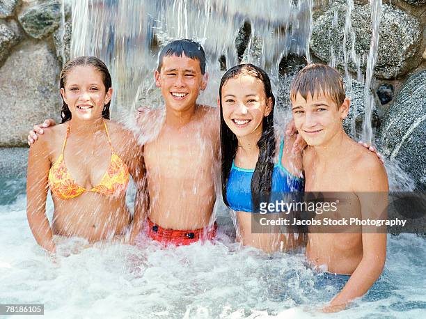 teenagers standing in pool with waterfall - pubescent girl stock pictures, royalty-free photos & images