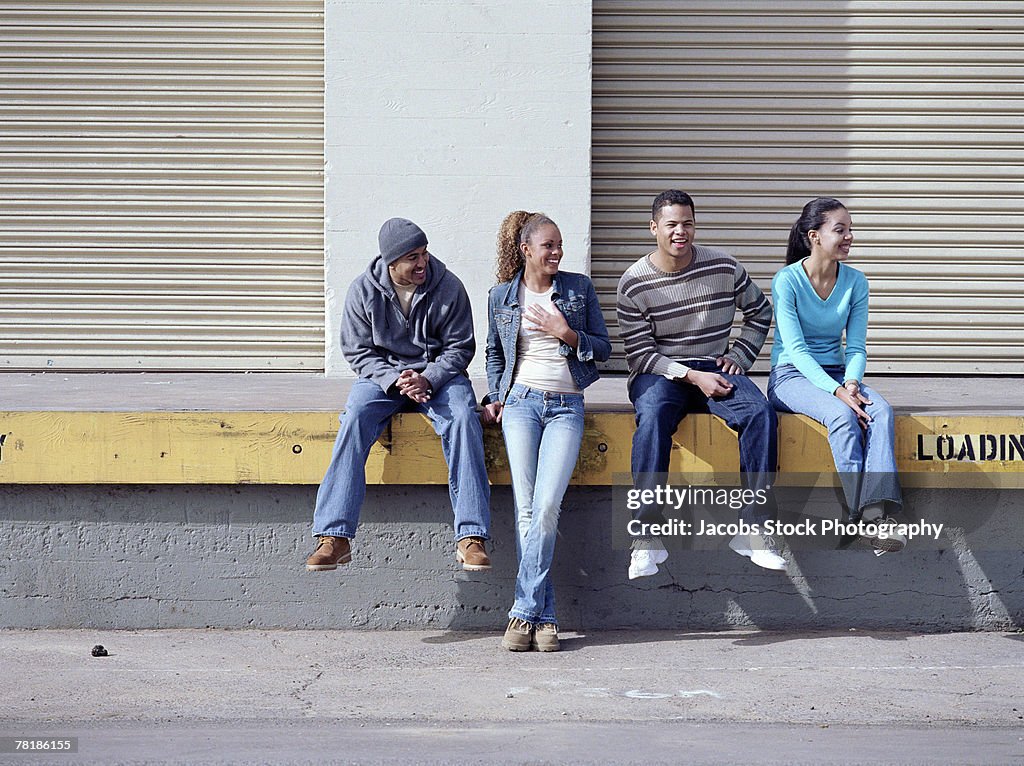 Friends sitting on a loading dock