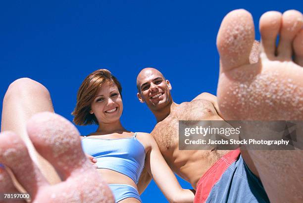 couple on beach with sand on feet - female hairy chest photos et images de collection