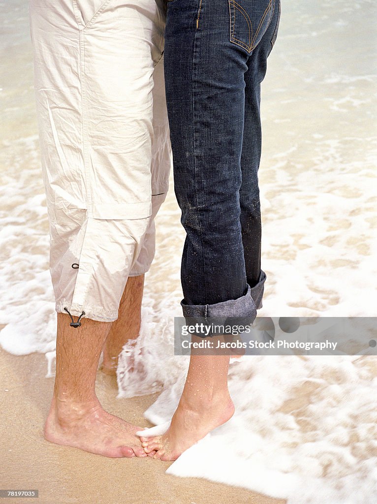 Legs of couple on beach