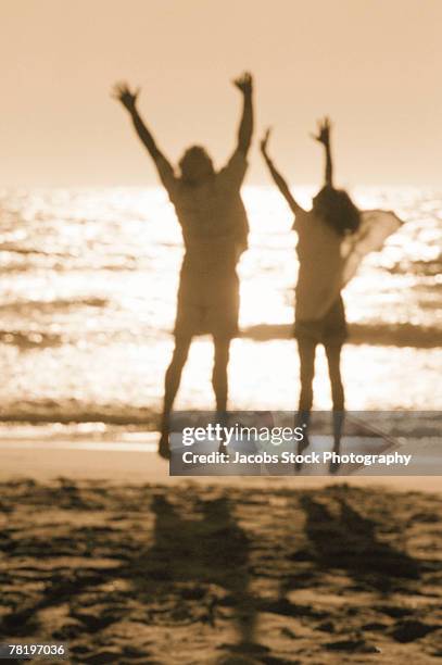 happy couple on beach - hands in the air heart stock-fotos und bilder