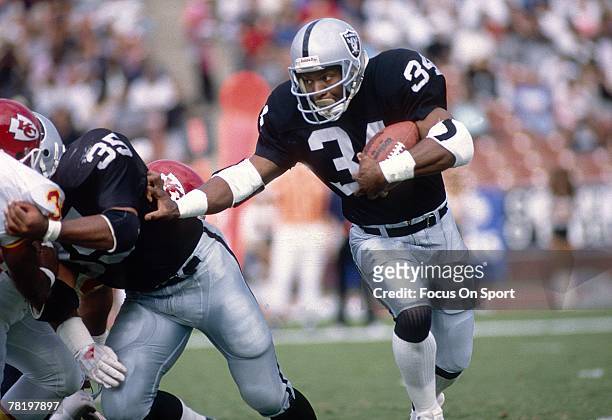 Running back Bo Jackson of the Los Angeles Raiders carries the ball during a circa late 1980's NFL game against the Kansas City Chiefs. Jackson...