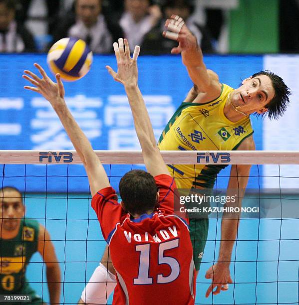 Brazilian volleyball star and captain Gilberto Godoy Filho "Giba" spikes the ball over Russian defender Alexander Volkov during their match at the...