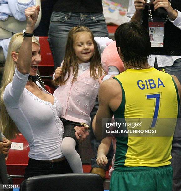 Brazilian volleyball star and captain Gilberto Godoy Filho "Giba" is congratulated by his wife and daughter after their team won against Russia at...