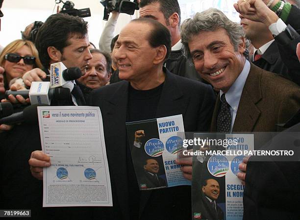 Former Italian Prime Minister Silvio Berlusconi shows the logo of his new party 01 December 2007 with Palermo Mayor Diego Cammarata i n Palermo...