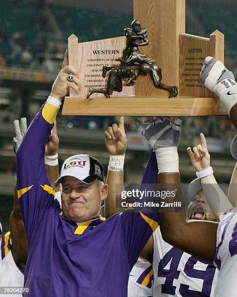 Head coach Les Miles of the LSU Tigers celebrates with the trophy after the SEC Championship game against the Tennessee Volunteers at the Georgia...