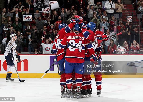 Guillaume Latendresse of the Montreal Canadiens celebrates his third period goal with team-mates as David Legwand of the Nashville Predators skates...