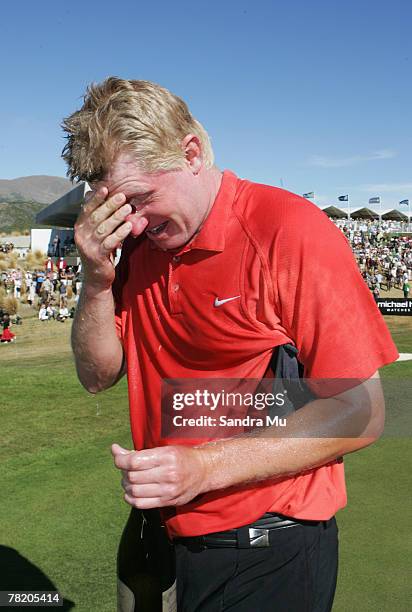 Richard Finch of England wipes the champagne from his eyes after friends celebrated on the 18th green following his win after the fourth round of the...