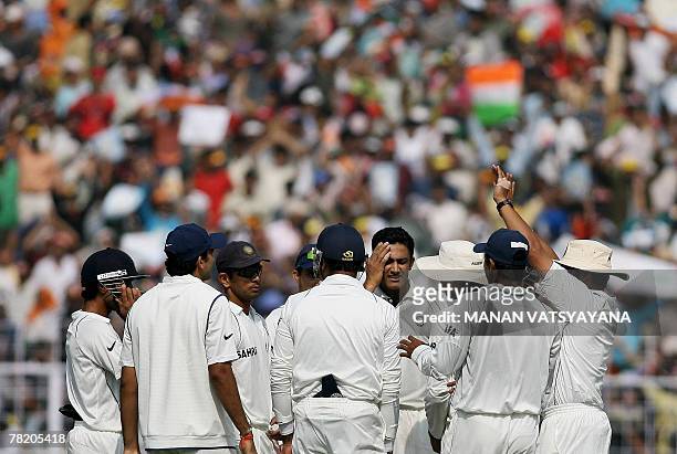 Indian cricket captain Anil Kumble celebrates with teammates after taking the wicket of Pakistani cricketer Faisal Iqbal during the third day of the...