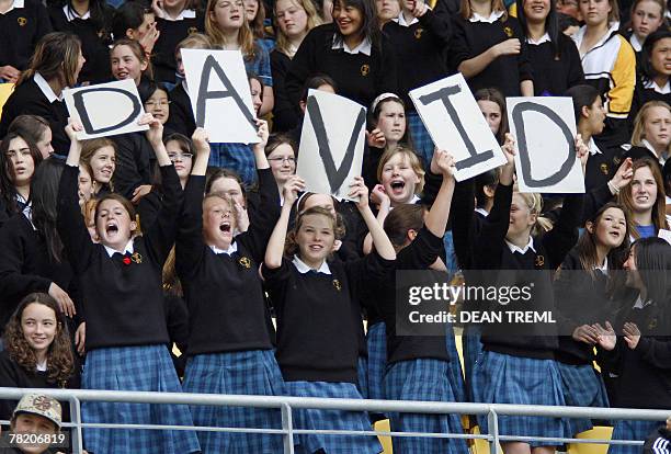 Schoolgirls hold up a message while British footballer David Beckham of the LA Galaxy trains in front of a crowd of thousands attending the team's...