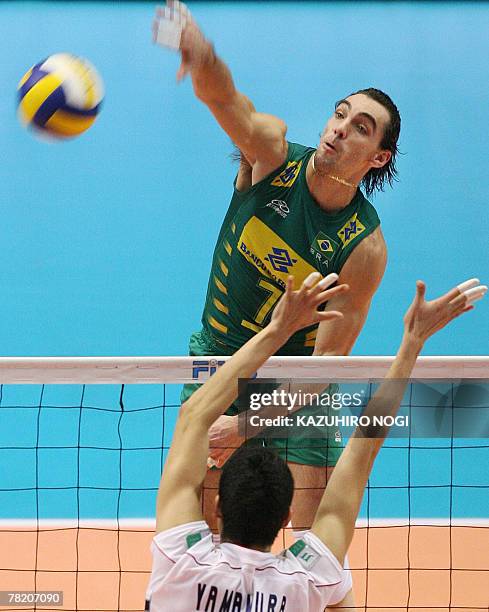 Brazilian attacker Gilberto Godoy Filho "Giba" spikes the ball over Japan's blocker Kota Yamamura during their match at the FIVB Men's World Cup...