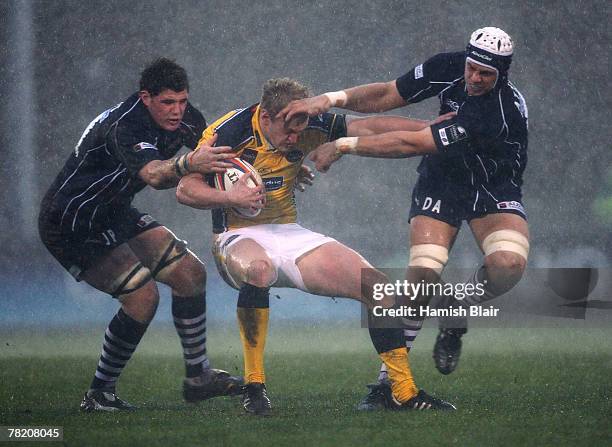 Lee Blackett of Leeds is tackled by James Phillips and Dave Attwood of Bristol during the EDF Energy Cup match between Bristol Rugby and Leeds...