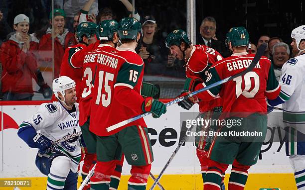 Aaron Voros of the Minnesota Wild talks to Byron Ritchie of the Vancouver Canucks while Marian Gaborik and James Sheppard of the Minnesota Wild try...