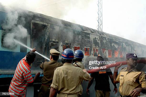 Indian firefighters atmpt to control the blaze in carriages on the Thirupathi-Secunderabad-Narayandri-Howrah Express train which caught fire at the...
