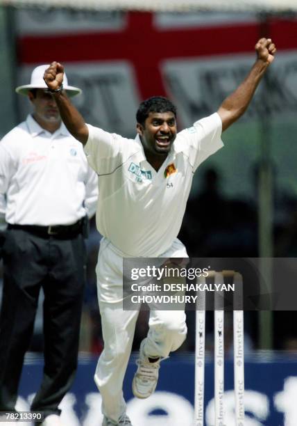 Sri Lankan bowler Muttiah Muralitharan reacts after breaking the world record tally of 708 wickets dismissing the unseen England cricketer Paul...