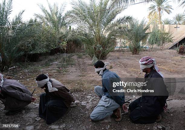 Men sit handcuffed and blindfolded after being detained by U.S. Soldiers in the 4th Stryker Brigade, 2nd Infantry out of Ft. Lewis, Washington,...