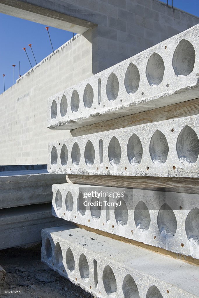 Concrete beams stacked ready to be applied to the second story of a commercial building under construction