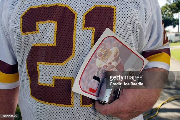 Washington Redskins fan Rich Samuel holds a funeral program as he attends the funeral of Redskins football player, Sean Taylor, at the Pharmed Arena...